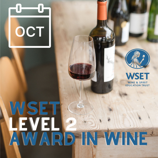 Wine bottle and glass on a wooden table with WSET Level 2 Award in Wine text and WSET logo.